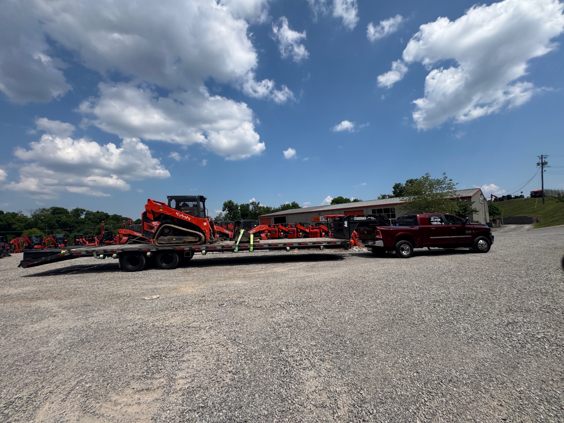 Veteran-owned truck and flatbed at staging area, patriotic flag visible