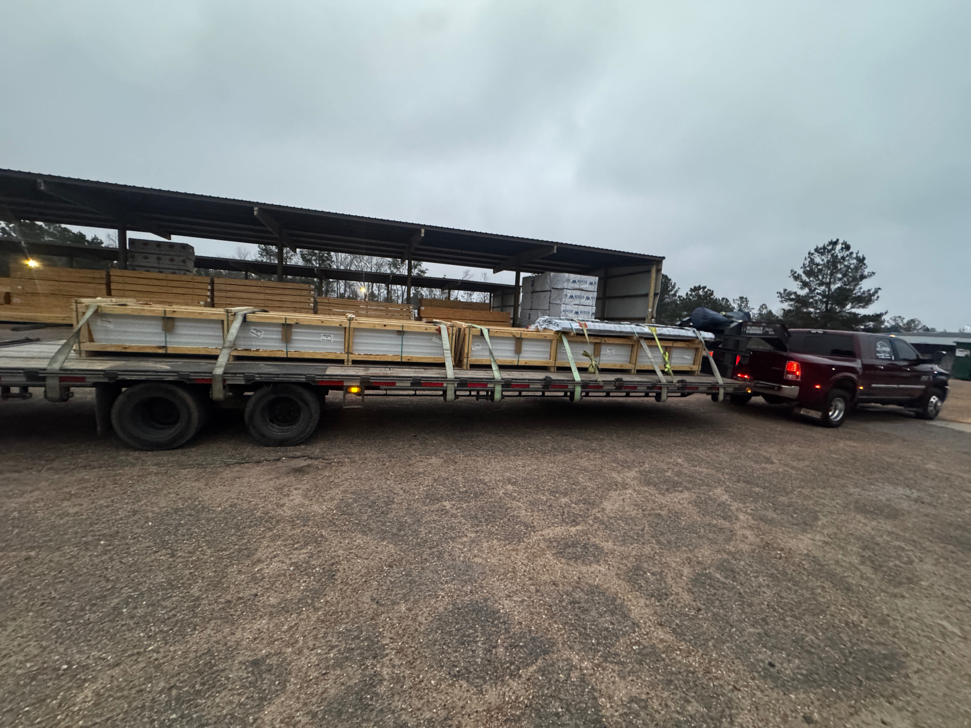 Skid steer loader on flatbed trailer, residential delivery