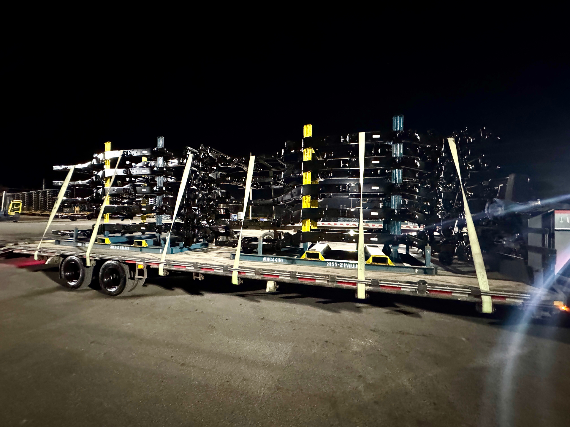 Agricultural machinery secured on flatbed, rural setting